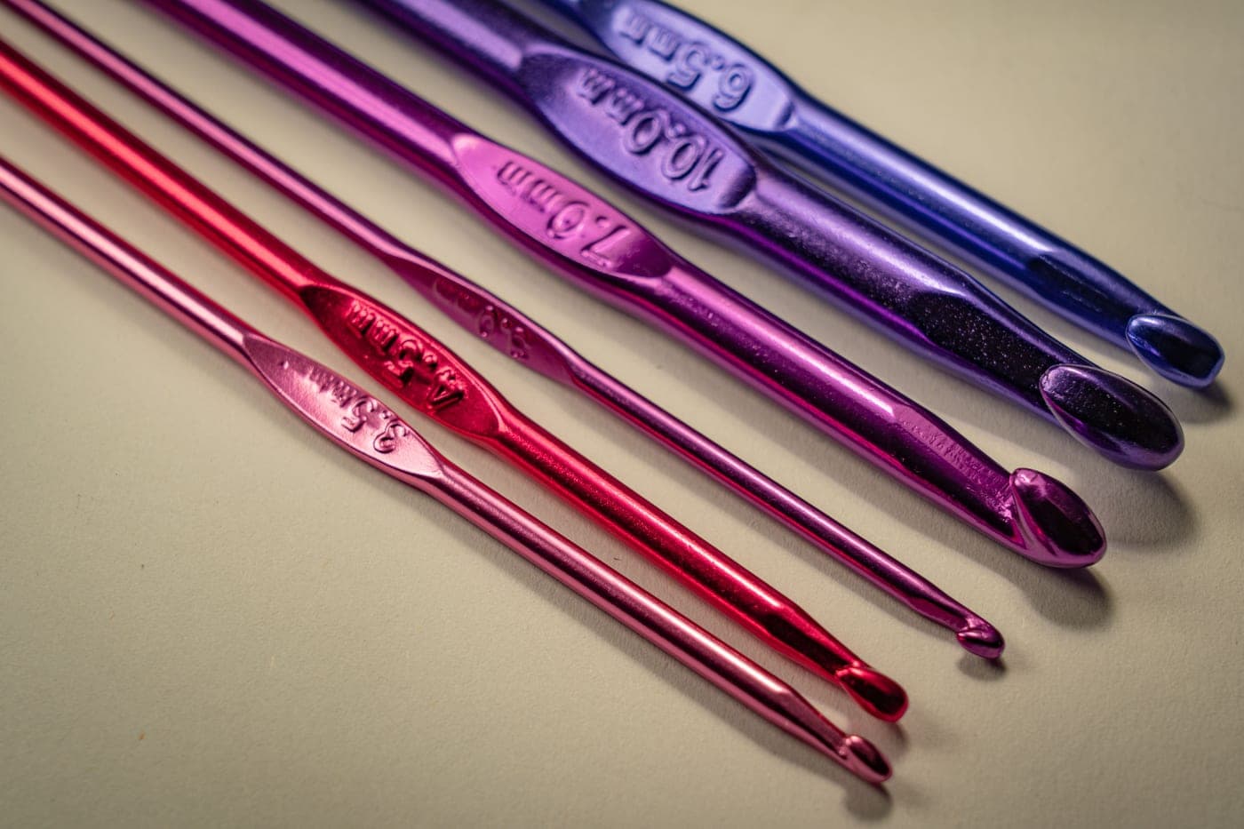 A set of crochet hooks arranged in size order on a plain surface