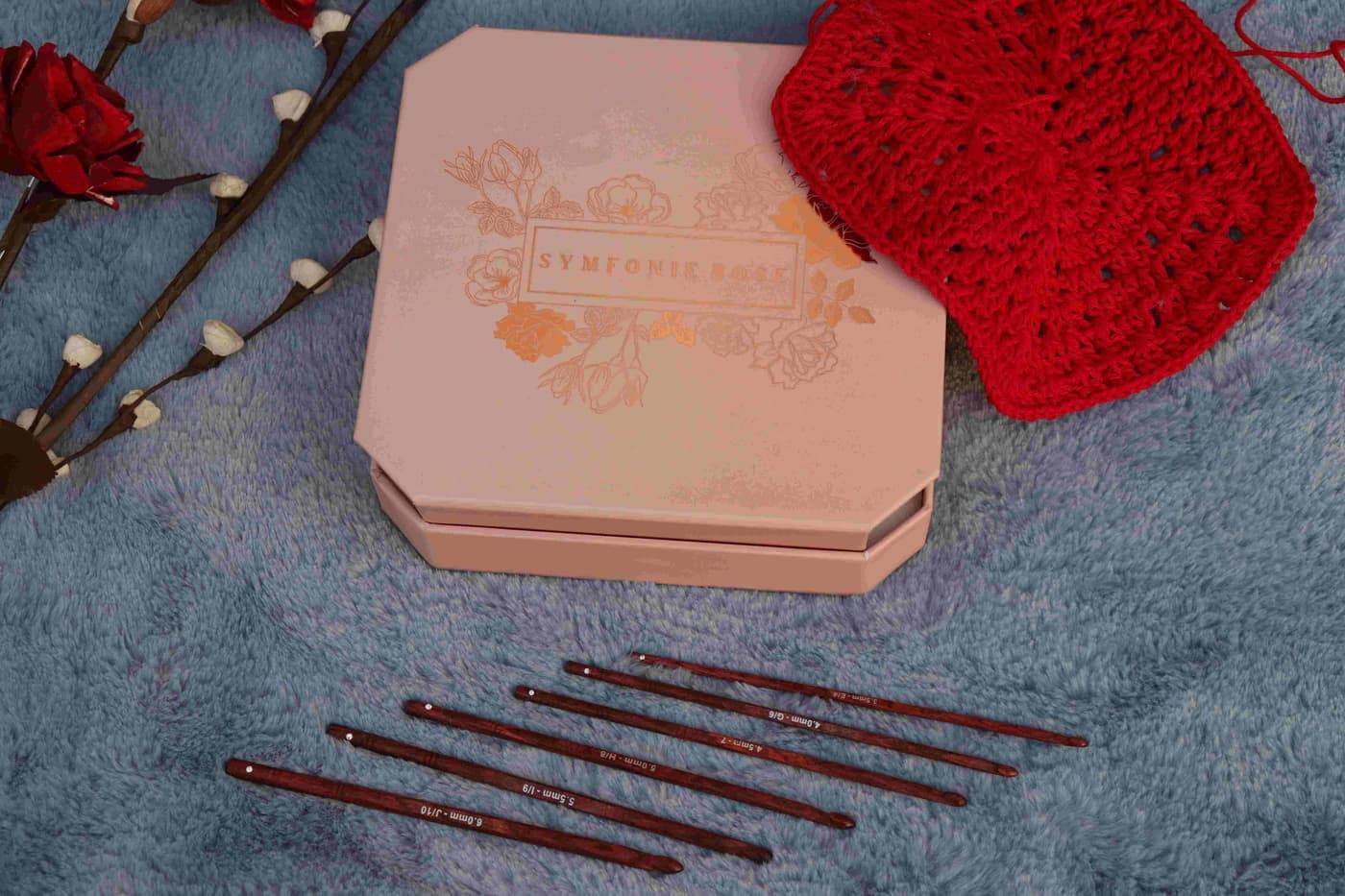 A beginner crochet kit laid out with hook, yarn and a partly worked piece